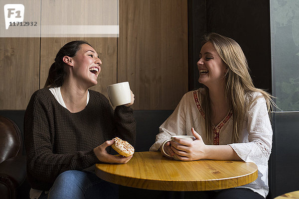 Zwei lachende Freunde in einem Coffee-Shop