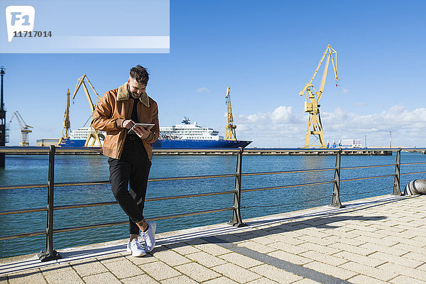 Spanien  Cadiz  Junger Mann am Hafen mit digitalem Tablett