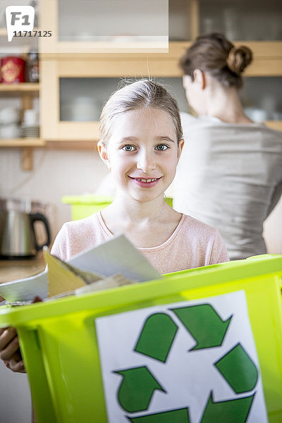 Porträt des lächelnden Mädchens zu Hause mit Abfallbehälter