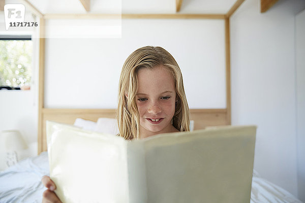 Porträt des Inhalts kleines Mädchen beim Lesen eines Buches zu Hause