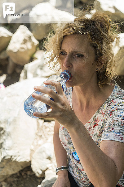 Frau auf einer Reise trinkt Wasser aus der Flasche