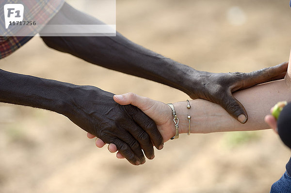 Burkina Faso  alter afrikanischer Mann beim Händeschütteln mit weißer Frau