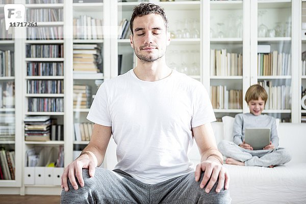 Mann meditiert zu Hause
