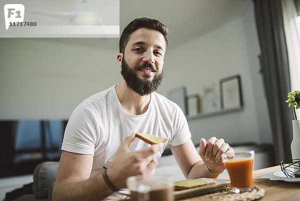 Porträt eines jungen Mannes beim Frühstück