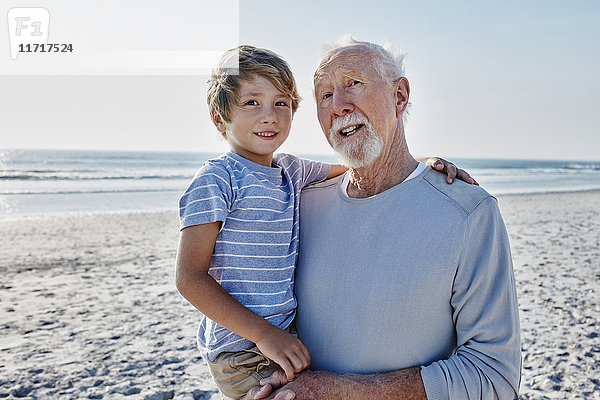 Großvater mit Enkel am Strand