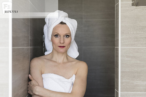 Porträt einer lächelnden Frau mit Handtüchern im Bad