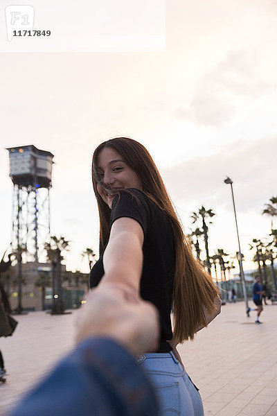 Spanien  Barcelona  glückliche junge Frau hält Hand