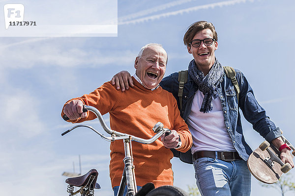 Porträt eines glücklichen älteren Mannes mit erwachsenem Enkel unterwegs