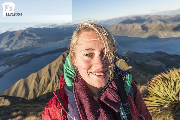 Wanderer lächelt in die Kamera  Roys Peak  Lake Wanaka  Südliche Alpen  Region Otago  Südland  Neuseeland  Ozeanien