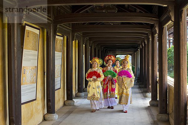 Vietnamesische Statisten in traditionellen Gewändern gehen durch den Kaiserpalast Hoang Thanh  Verbotene Stadt  Hue  Vietnam  Asien