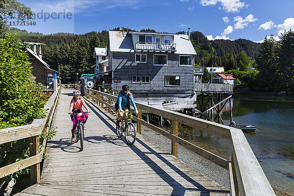 Mutter und Tochter fahren mit dem Fahrrad auf der historischen Uferpromenade in Seldovia  Süd-Zentral-Alaska  USA