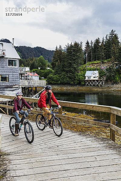 Mutter und Tochter radeln auf der historischen Uferpromenade  Seldovia  Süd-Zentral-Alaska  USA