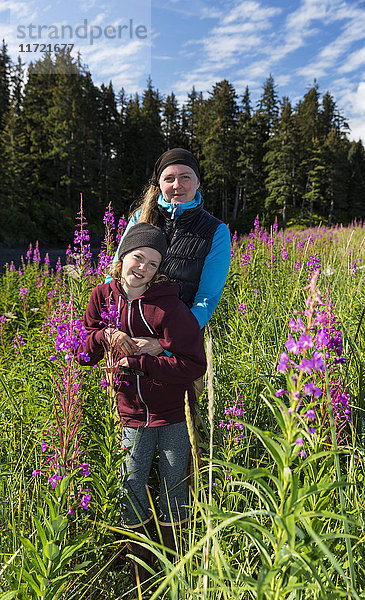 Mutter und Tochter stehen in einem Feld mit hohem Fireweed  Seldovia  Southcentral Alaska  USA