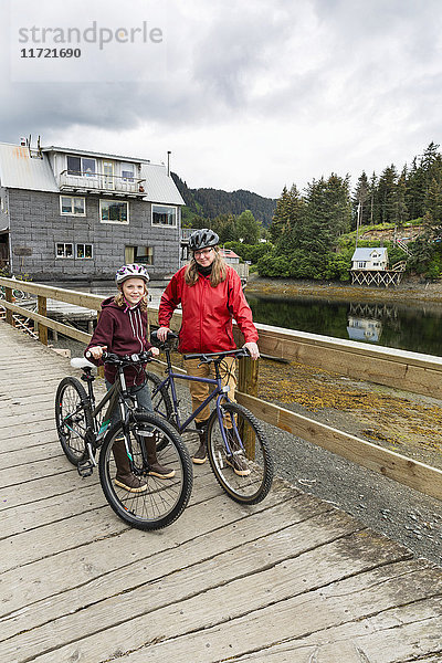 Mutter und Tochter mit Fahrrädern auf der historischen Uferpromenade von Seldovia  Süd-Zentral-Alaska  USA