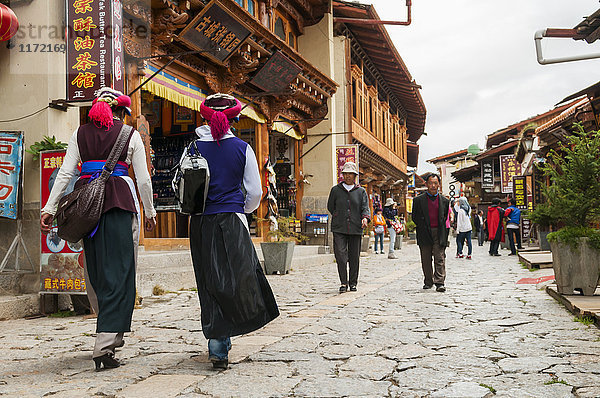 Eine alte Straße in der Altstadt von Shangrila  zwei Frauen einer Minderheitengruppe gehen spazieren; Shangri-La  Provinz Yunnan  China .
