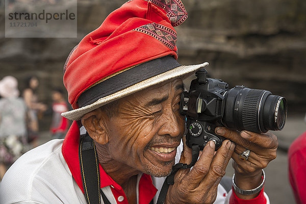 Offizieller Fotograf für Touristen im Tanah-Lot-Tempel; Insel Bali  Indonesien'.