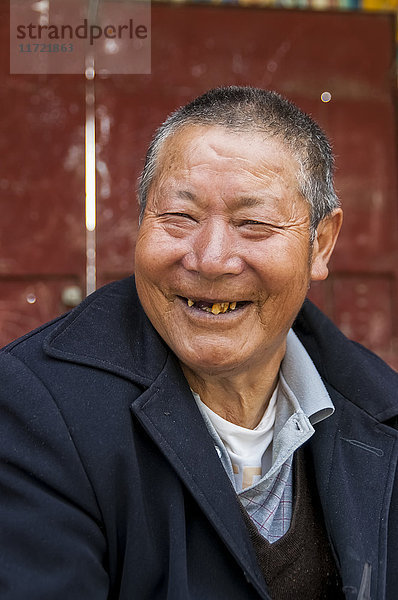 Porträt eines tibetischen Mannes  dem viele Zähne im Mund fehlen; Litang  Sichuan  China'.