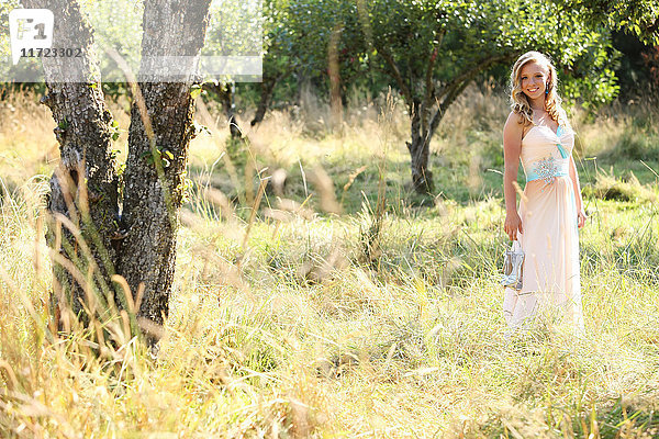 Eine junge Frau mit blondem Haar und wallendem Kleid steht in einem Feld mit hohem Gras; Oregon  Vereinigte Staaten von Amerika'.