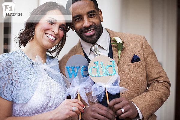 Braut und Bräutigam posieren mit Schildern  die ihr Eheversprechen symbolisieren; Portland  Oregon  Vereinigte Staaten von Amerika'.