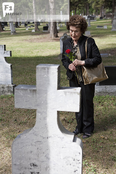 Eine Frau besucht ein Grab auf einem Friedhof; Edmonton  Alberta  Kanada .