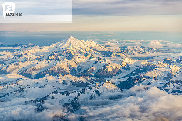Luftaufnahme von schneebedeckten Bergen und einem in Sonnenuntergangslicht getauchten Gipfel  Süd-Zentral-Alaska  USA