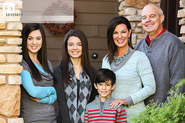 Porträt einer Familie mit drei Kindern  die an der Tür ihres Hauses stehen; Oregon  Vereinigte Staaten von Amerika'.