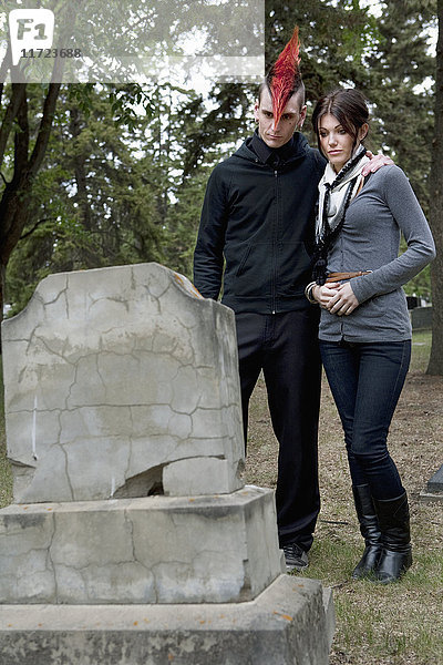 Ein junger Mann und eine junge Frau  die sich gegenseitig auf einem Friedhof unterstützen; Edmonton  Alberta  Kanada'.