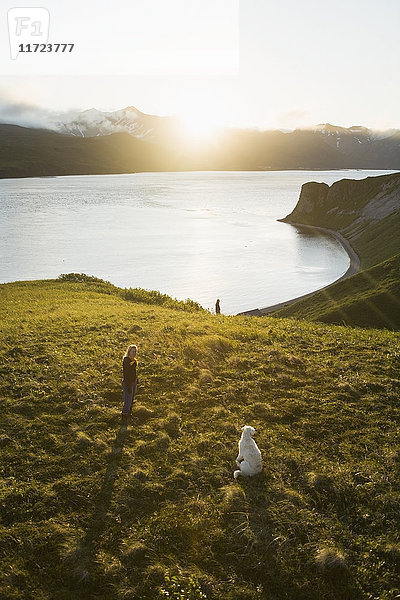 Zwei Mädchen gehen mit ihrem Hund durch das Muskeg auf der Klippe über dem Fischlager ihrer Familie; False Pass  Alaska  Vereinigte Staaten von Amerika'.