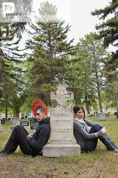 Ein junger Mann und eine junge Frau  die an einem Grabstein sitzen; Edmonton  Alberta  Kanada .