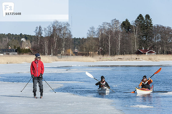 Menschen beim Kajakfahren und Skifahren