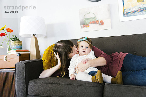 Mutter und Tochter (12-17 Monate) auf dem Sofa