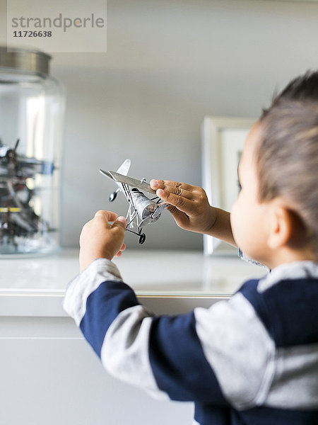 Junge (2-3) spielt mit Modellflugzeug