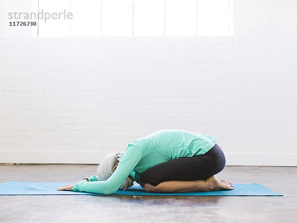 Ältere Frau übt Yoga auf der Matte