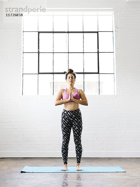 Frau übt Yoga auf Übungsmatte