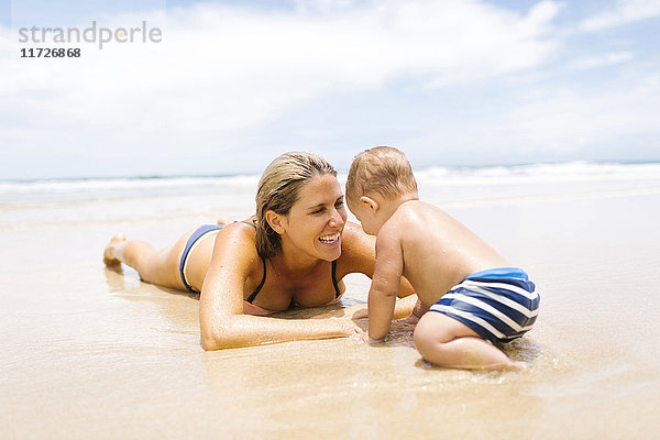 Mutter spielt mit Sohn (12-17 Monate) am Strand