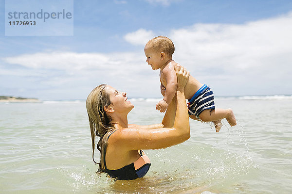 Mutter spielt mit Sohn (12-17 Monate) im Meer