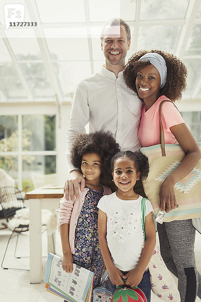 Portrait lächelnde multiethnische junge Familie bereit zum Verlassen des Hauses