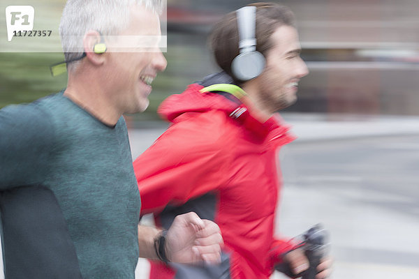 Lächelnde männliche Läufer mit laufendem Kopfhörer