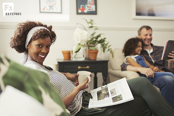 Portrait lächelnde Frau entspannt mit Tee und Magazin auf Sofa