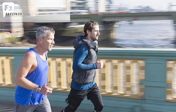 Männliche Läufer auf sonniger Stadtbrücke