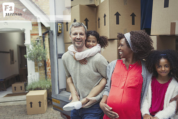 Portrait lächelnd schwangere multiethnische junge Familie beim Einzug ins neue Haus