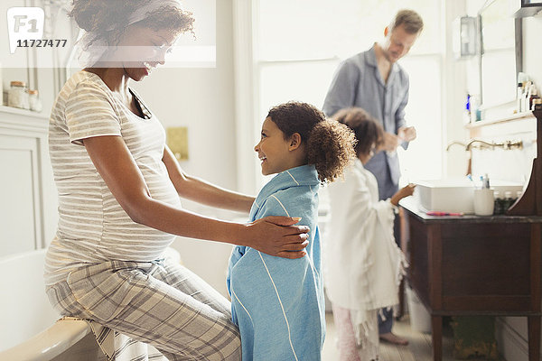 Schwangere Mutter Wickeltuch auf Tochter nach dem Baden