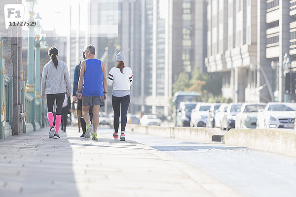 Läufer  die auf dem sonnigen städtischen Bürgersteig laufen