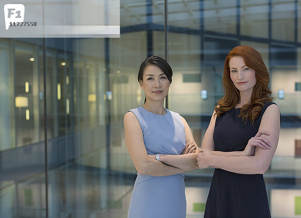 Portrait selbstbewusste Geschäftsfrauen im modernen Büroatrium