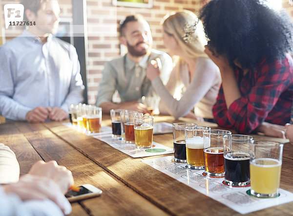 Freunde verkosten Bierproben in der Brauerei