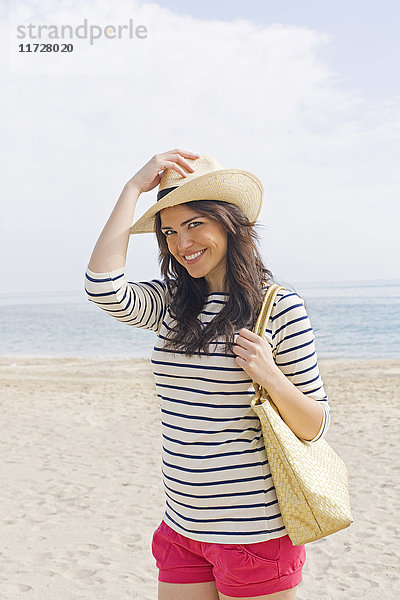 Porträt einer jungen brünetten Frau  die am Strand ankommt