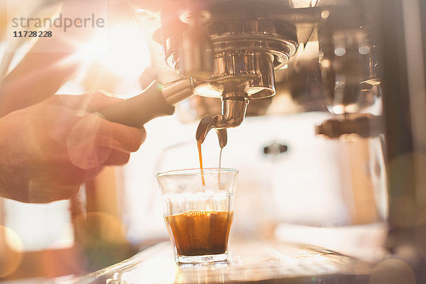 Nahaufnahme der Hand eines Barista  der eine Espressomaschine in einem Café benutzt