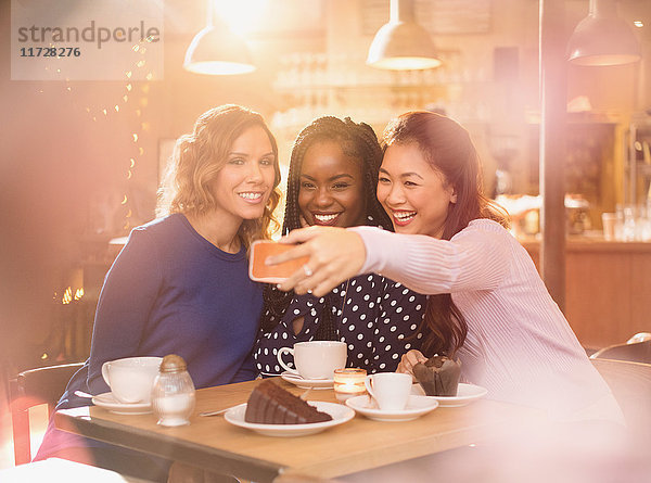 Lächelnde Frauen Freunde nehmen Selfie mit Kamera-Handy im Café Tisch