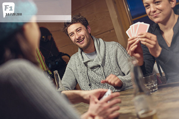 Freunde spielen Karten am Tisch in der Kabine
