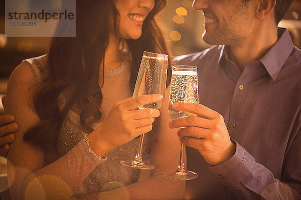 Verliebtes Paar stößt mit Champagnerflöten an